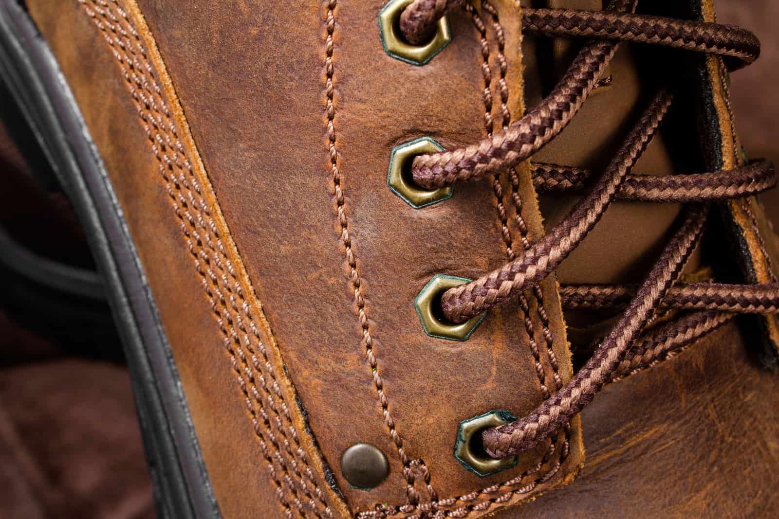 Close-up of a brown leather boot showing the lace and stitching