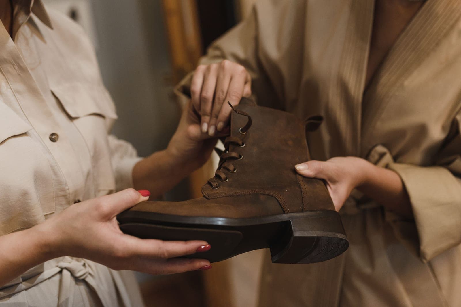 A brown leather boot being examined and handled closely